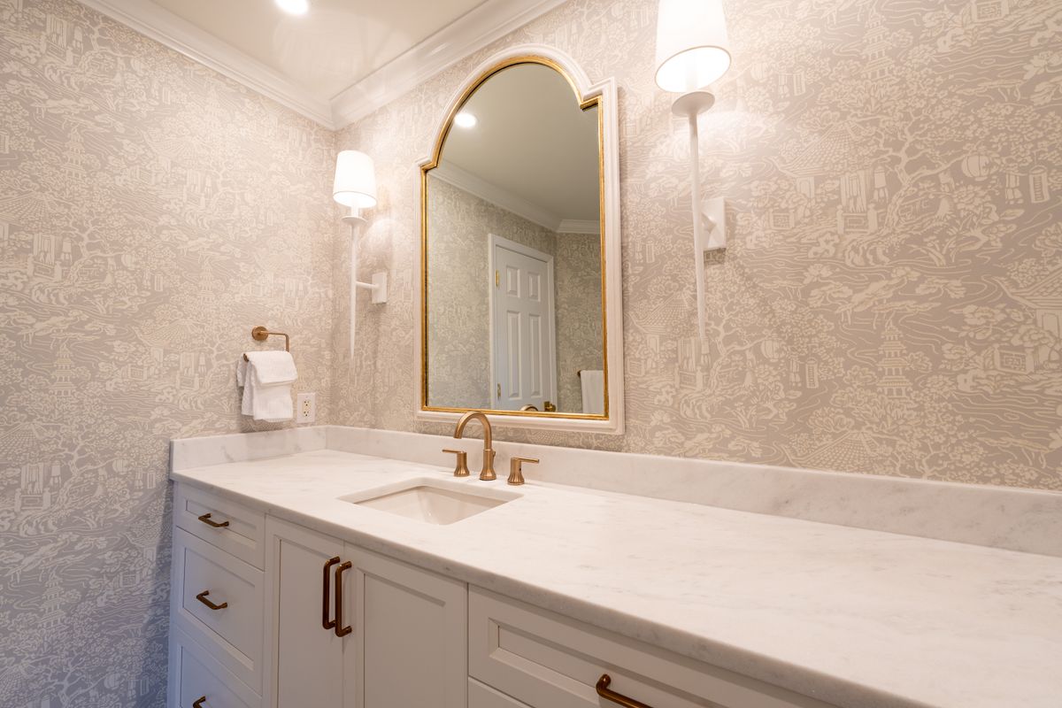 Elegant marble bathroom vanity with gold-framed mirror